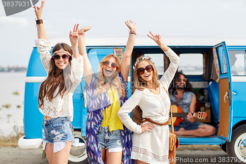 Image of happy hippie friends having fun over minivan car