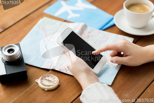 Image of close up of traveler hands with smartphone and map