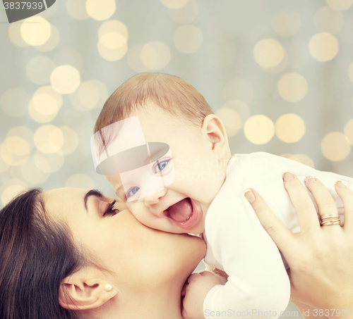 Image of happy mother with baby over lights background