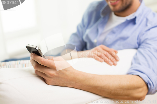 Image of close up of man with smartphone at home