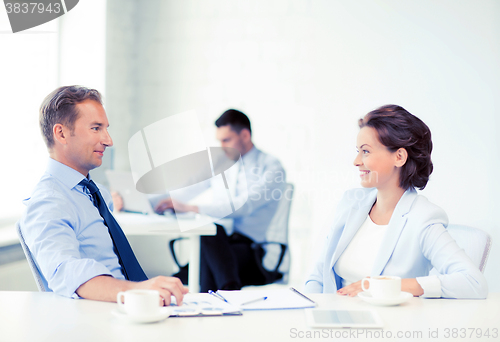 Image of man and woman discussing something in office