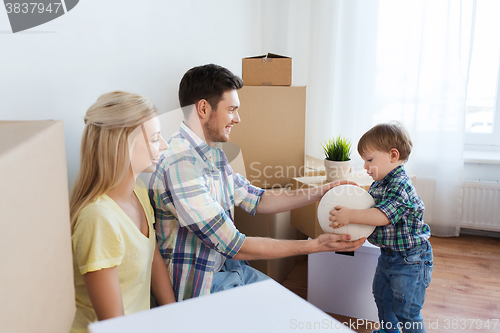 Image of happy family moving to new home and playing ball