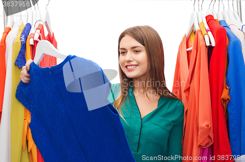 Image of happy woman choosing clothes at home wardrobe