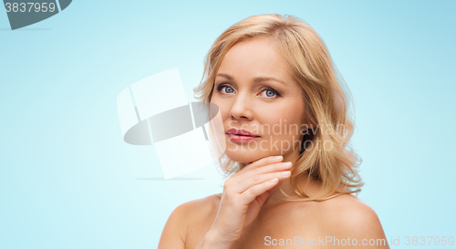 Image of woman with bare shoulders touching face