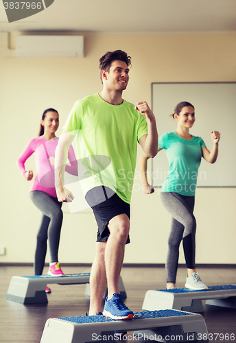 Image of group of people working out with steppers in gym