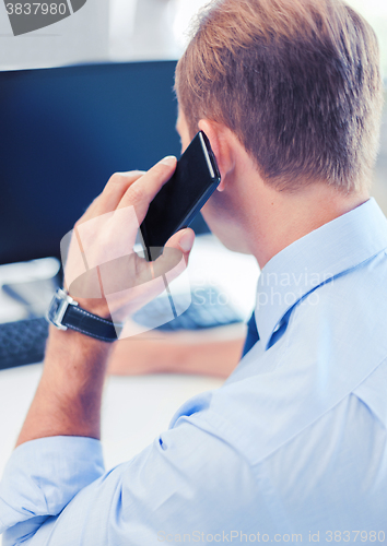 Image of businessman with smartphone in office