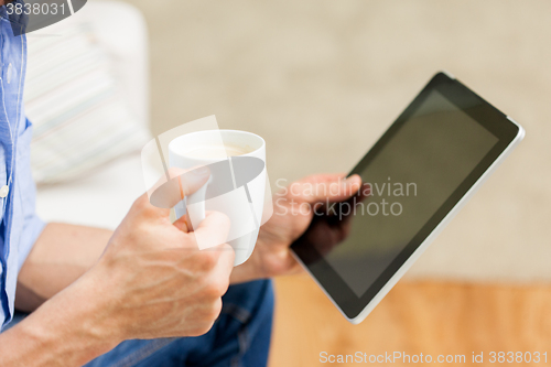 Image of close up of man with tablet pc and tea cup at home