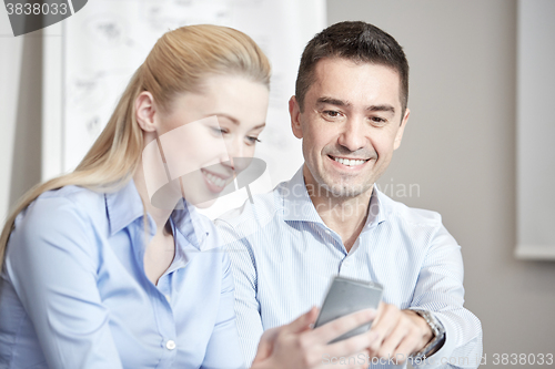 Image of smiling businesspeople with smartphones in office