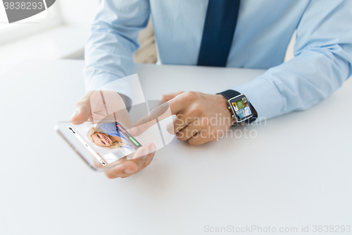 Image of close up of hands with smart phone and watch