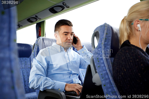 Image of man with smartphone and laptop in travel bus