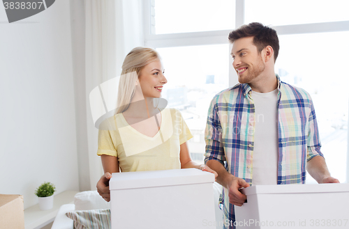 Image of smiling couple with big boxes moving to new home