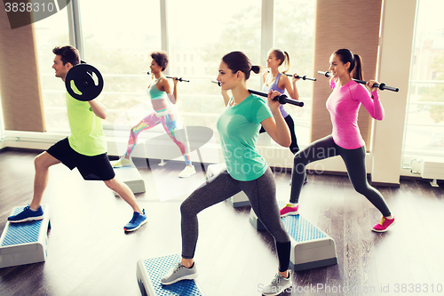 Image of group of people exercising with barbell in gym