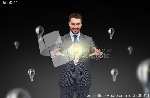 Image of businessman working with light bulb icons