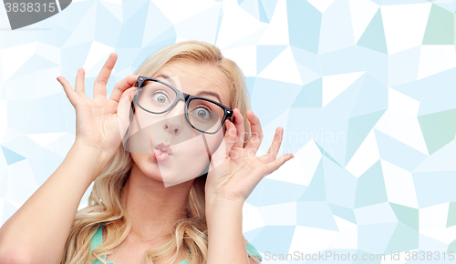 Image of happy young woman in glasses making fish face