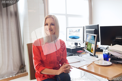 Image of happy creative female office worker with computers