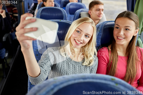 Image of women taking selfie by smartphone in travel bus