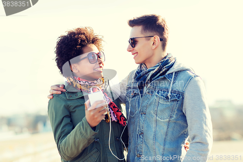 Image of smiling couple with smartphone and earphones