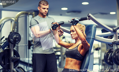 Image of man and woman flexing muscles on gym machine