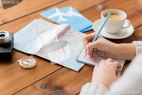 Image of close up of traveler hands with notepad and pencil