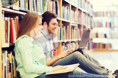 Image of happy students with laptop in library