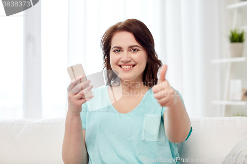 Image of plus size woman with smartphone showing thumbs up