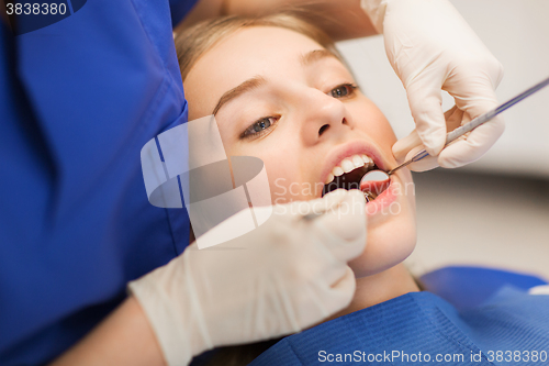 Image of female dentist checking patient girl teeth