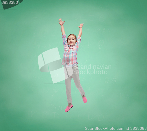 Image of happy little girl jumping in air over school board