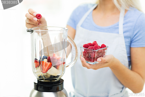 Image of close up of woman with blender making fruit shake