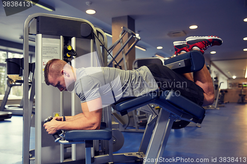 Image of man flexing leg muscles on gym machine