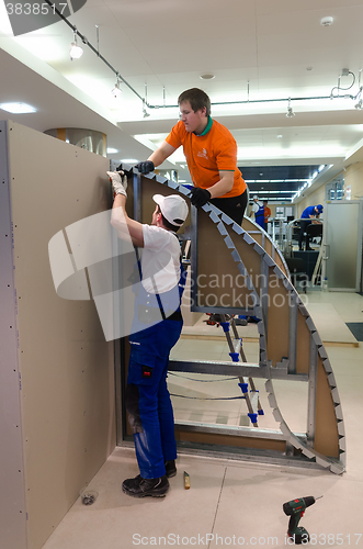 Image of Young workers performs task with gypsum cardboard