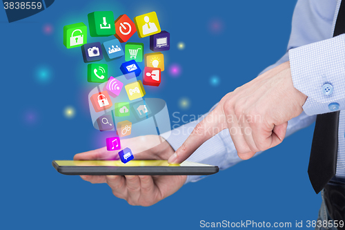 Image of Businessman holding a tablet pc with mobile applications icons on virtual screen . Internet and business concept.