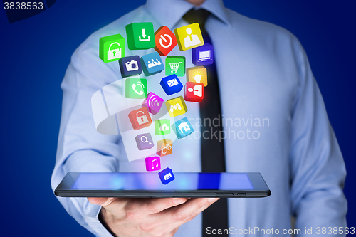 Image of Businessman holding a tablet pc with mobile applications icons on virtual screen . Internet and business concept.