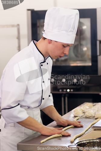 Image of Young cook prepares food in competition