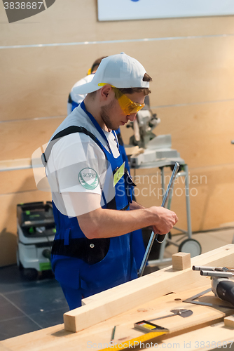 Image of Young carpenter performs task of competition