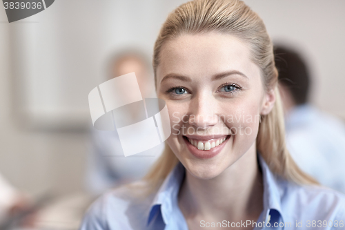 Image of group of smiling businesspeople meeting in office