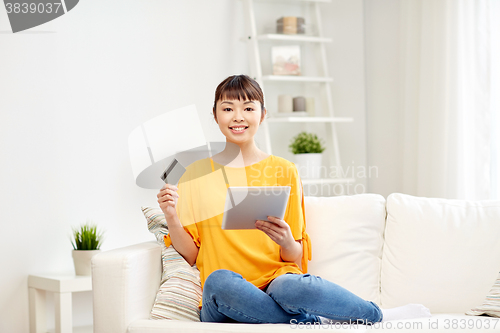 Image of happy asian woman with tablet pc and credit card