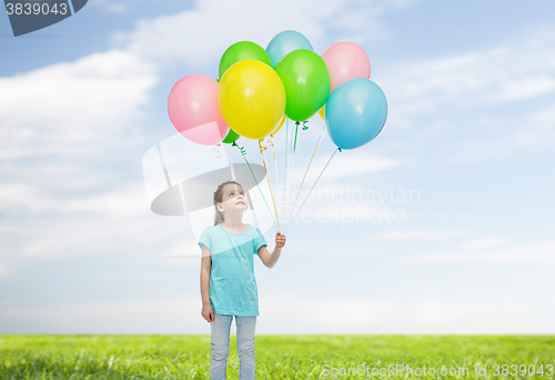 Image of girl looking up with bunch of helium balloons