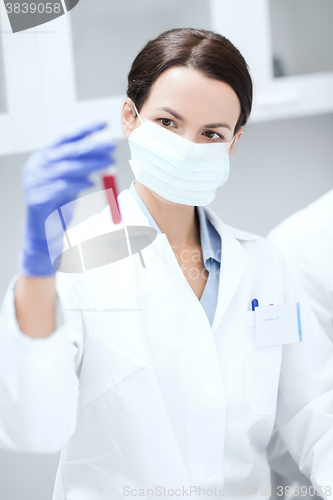 Image of close up of scientist holding test tube in lab
