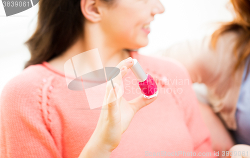 Image of close up of smiling young woman with nail polish