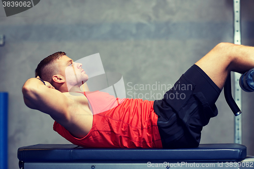 Image of young man making abdominal exercises in gym