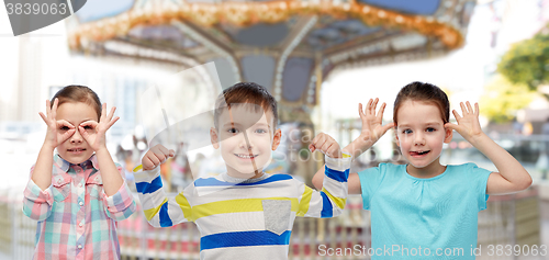 Image of happy little children having fun over carousel