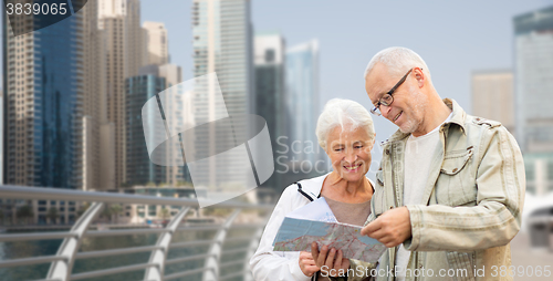 Image of happy senior couple with map over dubai city