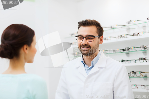 Image of woman and optician in glasses at optics store