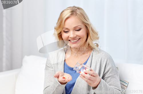 Image of happy middle aged woman with medicine at home