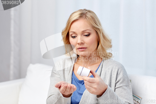 Image of middle aged woman with medicine at home