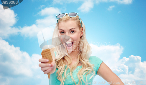 Image of happy young woman in sunglasses eating ice cream