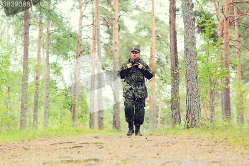 Image of young soldier with backpack in forest