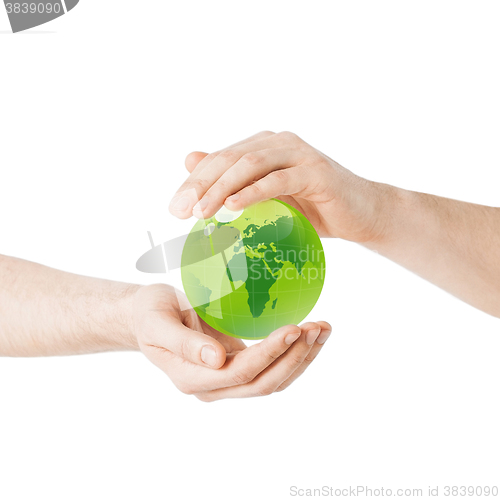 Image of close up of hands holding green globe
