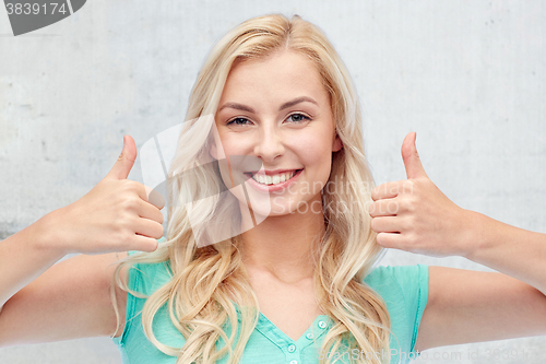 Image of happy woman or teenage girl showing thumbs up