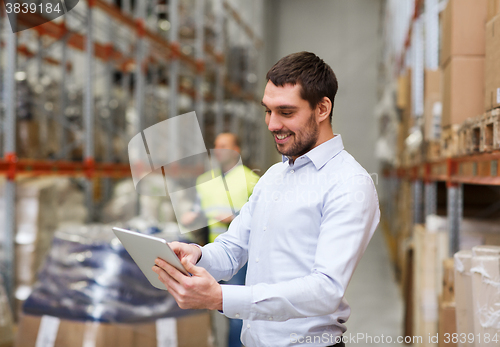 Image of happy businessman with clipboard at warehouse